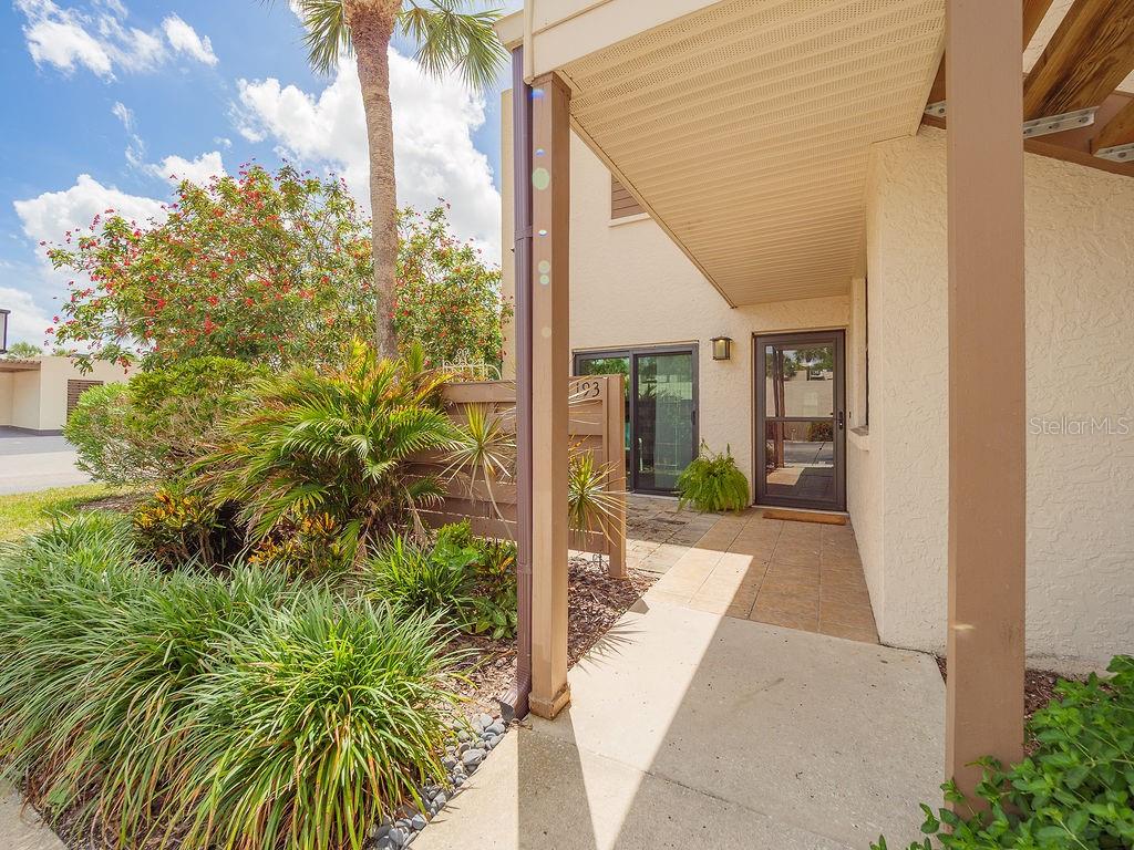The exterior entrance of a residential unit features a covered walkway and a glass door — 193 PINENEEDLE DRIVE, BRADENTON, FL
