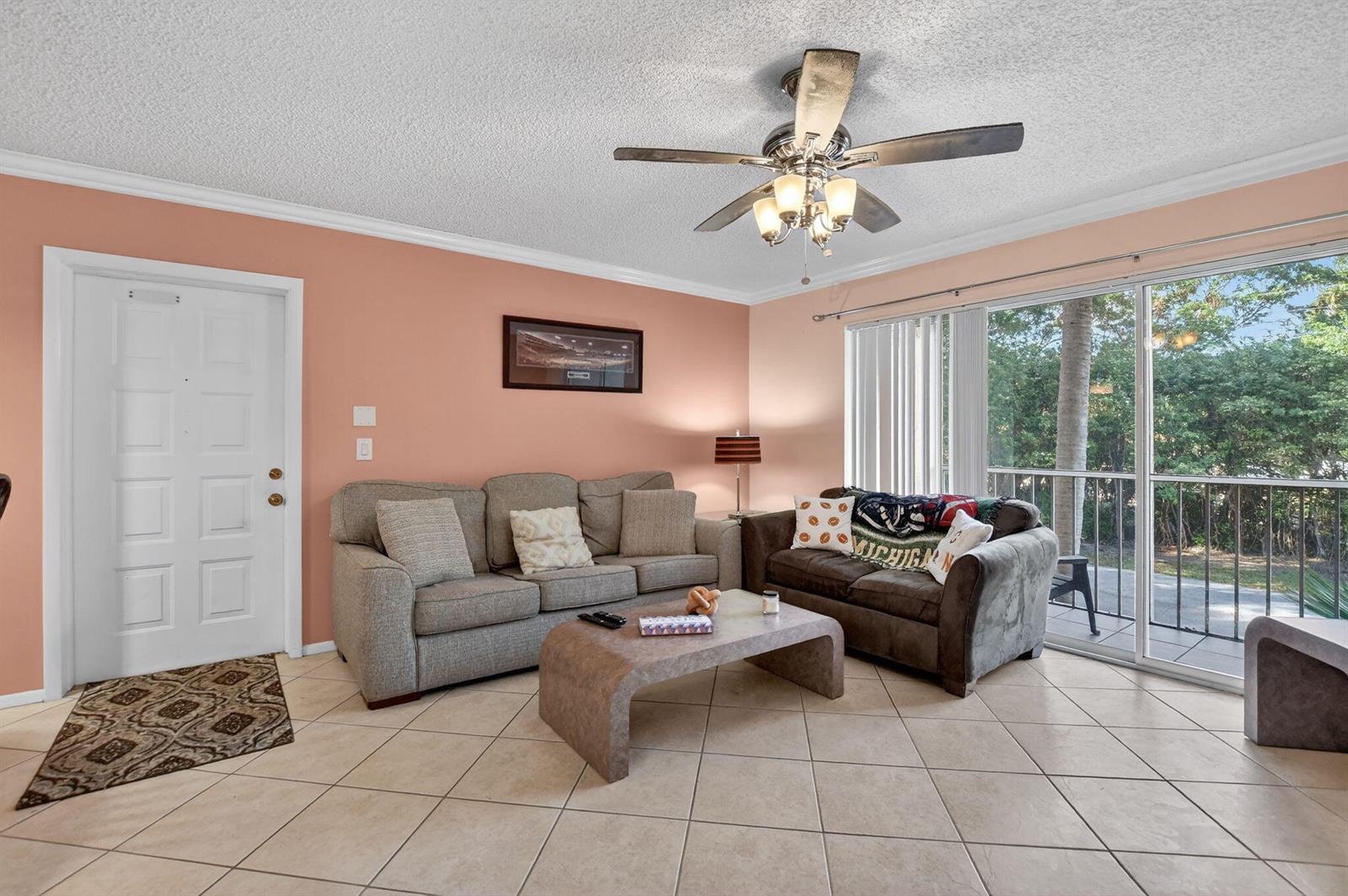 A living room features a beige sofa, a brown loveseat, a coffee table, and tile flooring — 13791 Oneida Drive # C2, Delray Beach FL 33446, DELRAY BEACH, FL