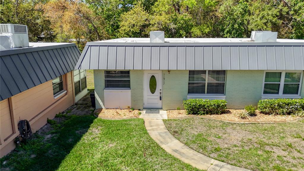 A light green brick house with a metal mansard roof and a white front door — 11917 BAYONET LANE UNIT 11917, NEW PORT RICHEY, FL