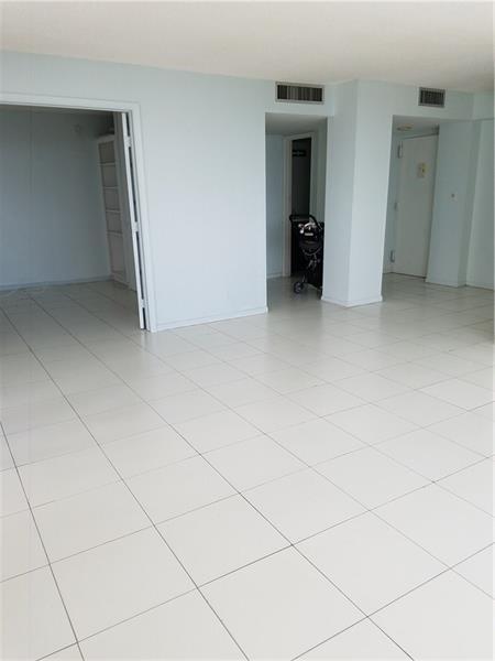 An empty room with white tile flooring and multiple doorways leading to other areas — 111 Briny Avenue # 2011, Pompano Beach FL 33062, POMPANO BEACH, FL