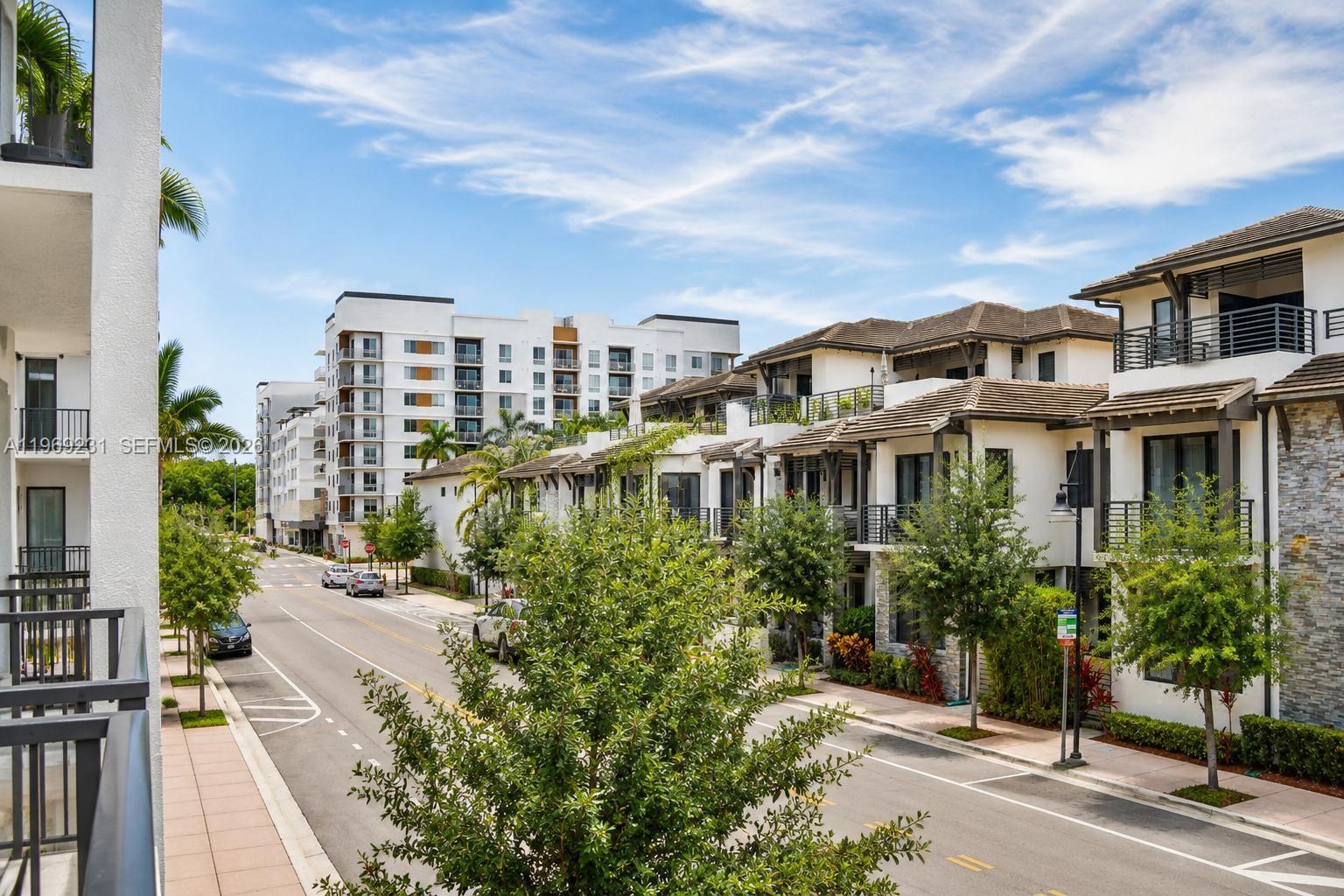 An elevated view shows a street lined with modern apartment buildings and townhomes under a blue sky — 4745 NW 84th Ct # 14, Doral FL 33166, DORAL, FL