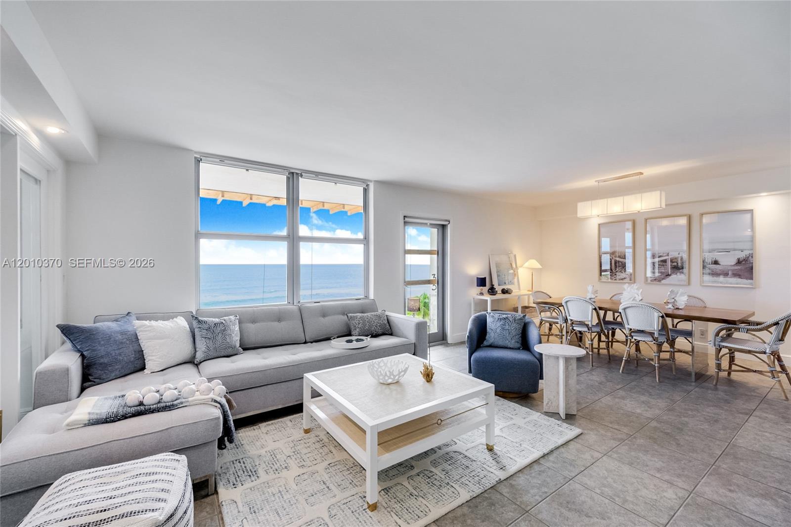 A living and dining area features tile floors, a gray sectional, and ocean views — 9225 Collins Ave # 501, Surfside FL 33154, SURFSIDE, FL