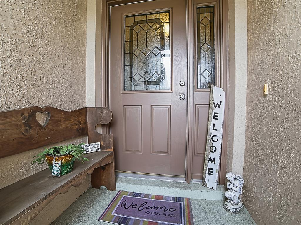 A front entryway features a wooden bench, a welcome sign, and a door with glass — 5052 CHINA SEA, TAVARES, FL