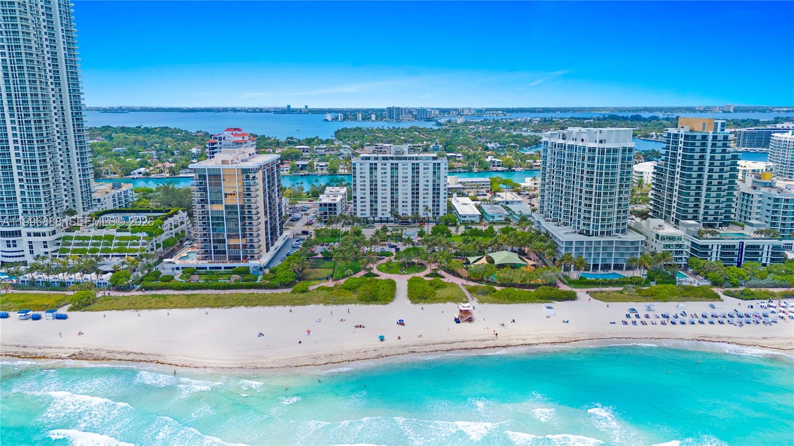 An aerial view shows a beach, a park, and several high-rise residential buildings — 6450 Collins Ave # 204, Miami Beach FL 33141, MIAMI BEACH, FL