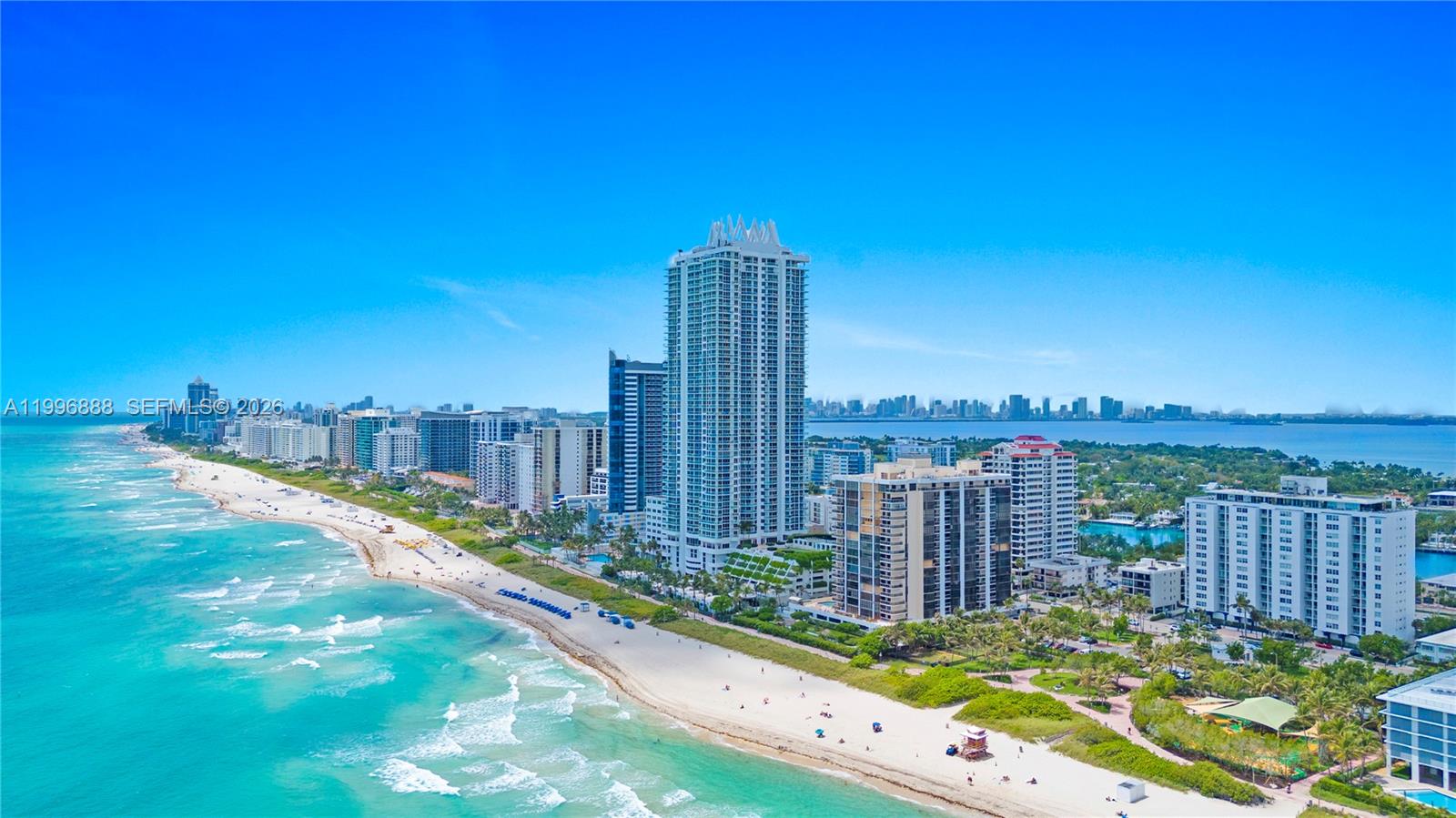 An aerial view of a sandy beach lined with high-rise buildings along the ocean — 6450 Collins Ave # 204, Miami Beach FL 33141, MIAMI BEACH, FL