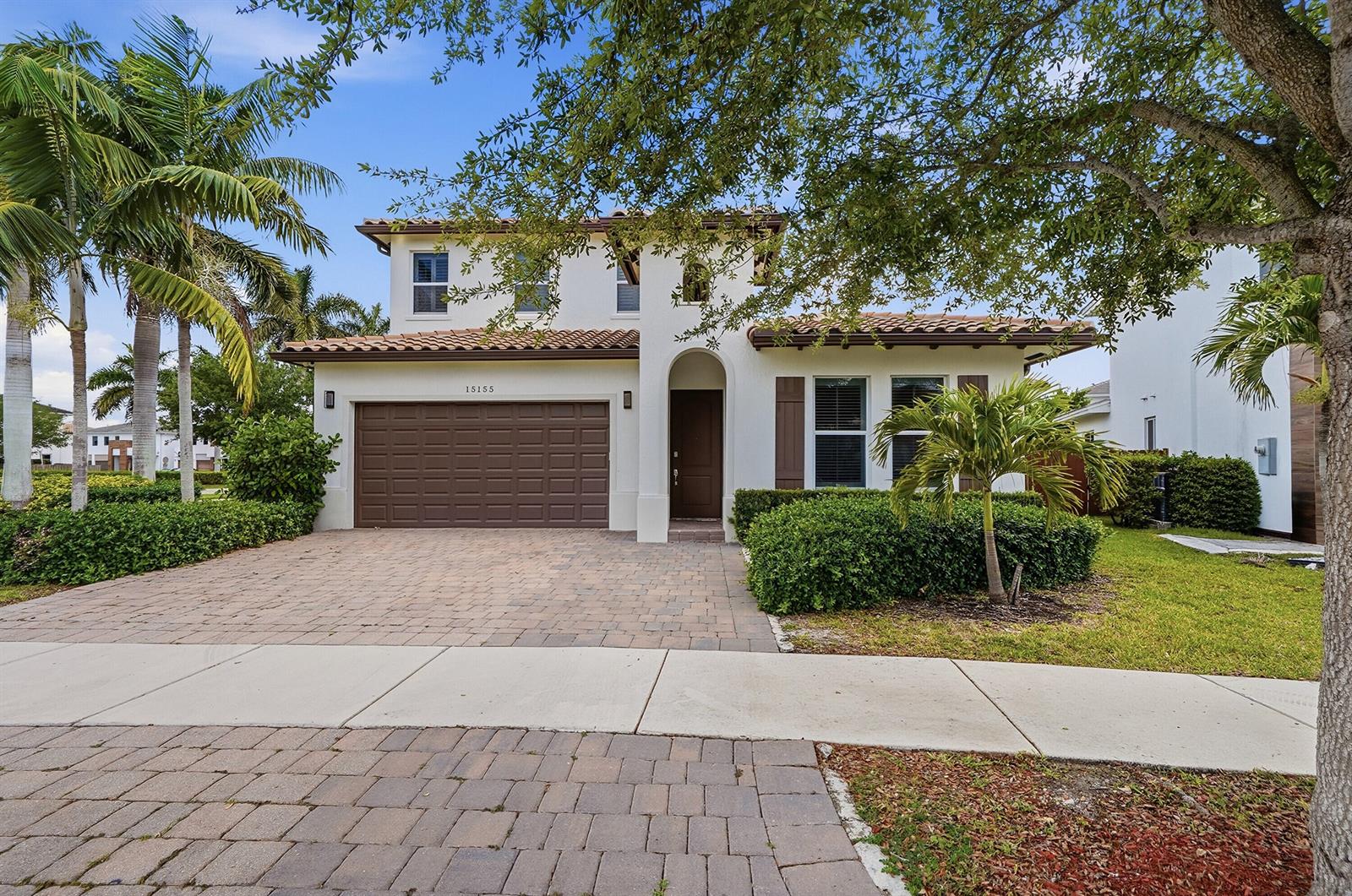 A two-story house with a brown garage door, arched entryway, and a paved driveway — 15155 SW 176th Lane, Miami FL 33187, MIAMI, FL