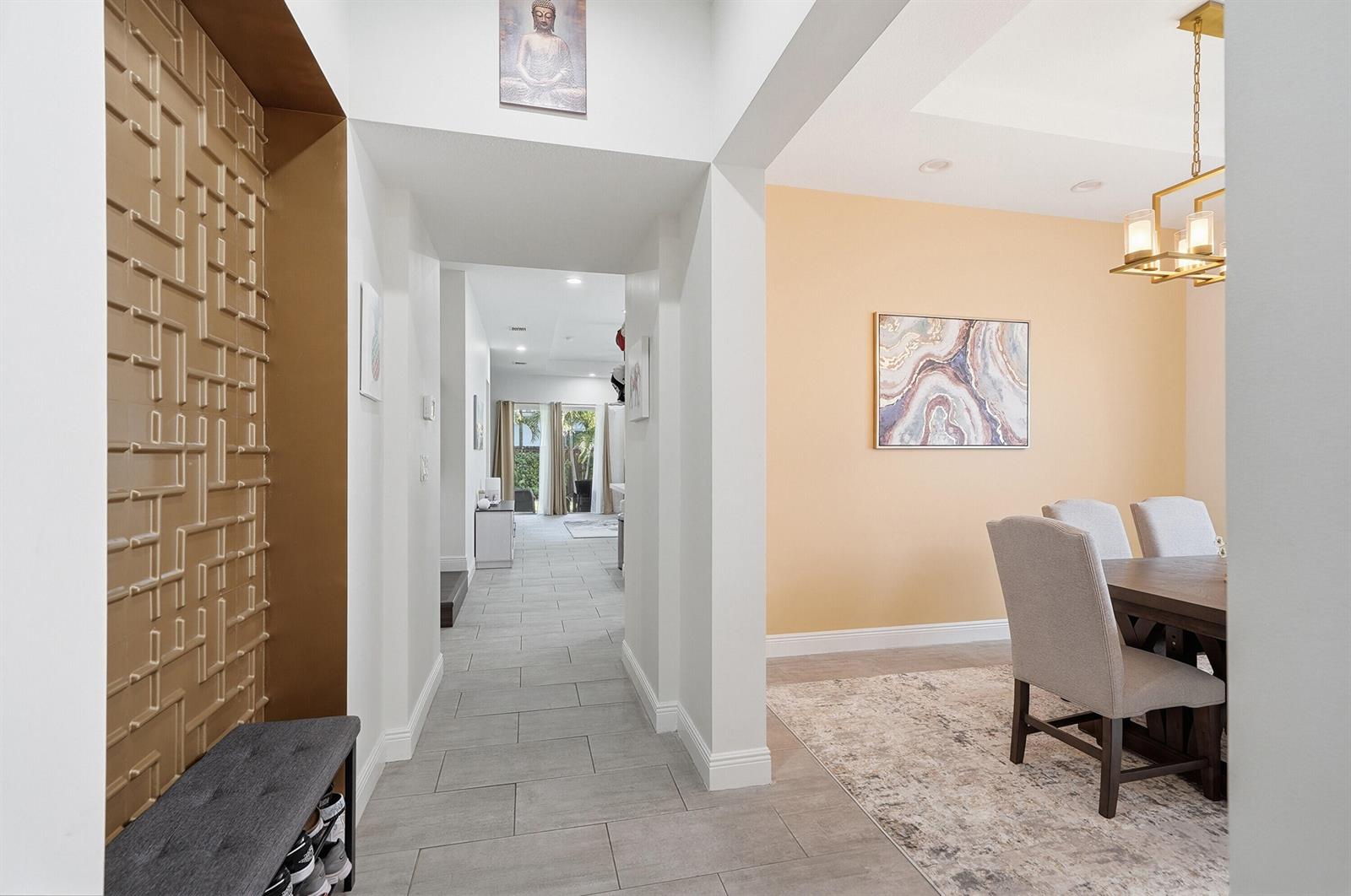 A hallway with a gold textured accent wall leads to a dining room with peach walls — 15155 SW 176th Lane, Miami FL 33187, MIAMI, FL