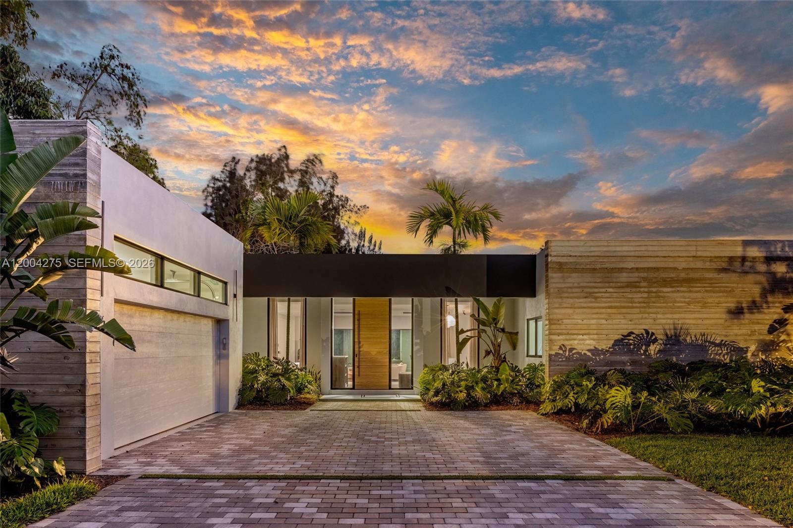 A modern house exterior features a paved driveway, wooden front door, and horizontal wood siding — 5700 Cypress Rd, Plantation FL 33317, PLANTATION, FL