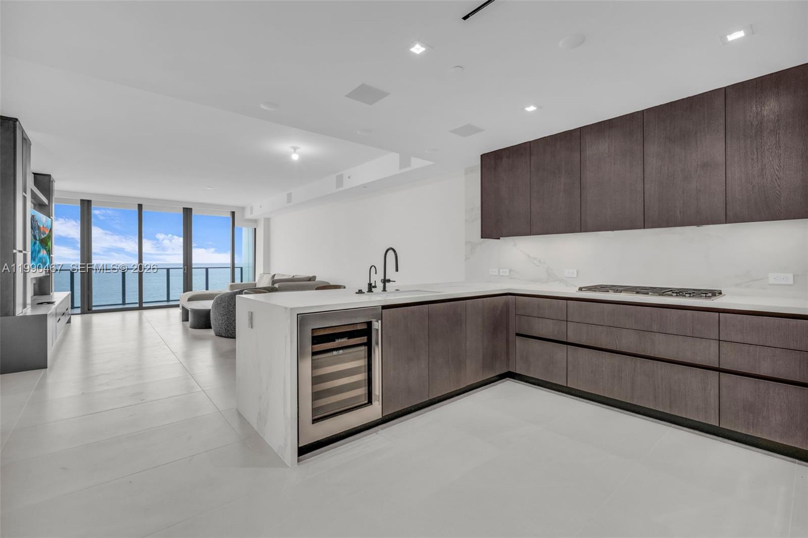 A modern kitchen features dark wood cabinetry, white countertops, and an ocean view — 1116 N Ocean Blvd # 1106, Pompano Beach FL 33062, POMPANO BEACH, FL