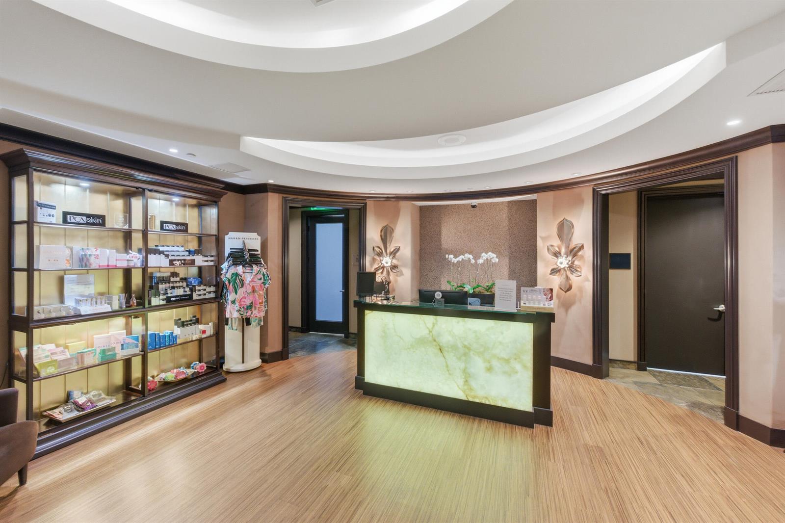 A reception area features a glowing stone desk, wood flooring, and a large display shelf — 2495 NW 66th Drive, Boca Raton FL 33496, BOCA RATON, FL