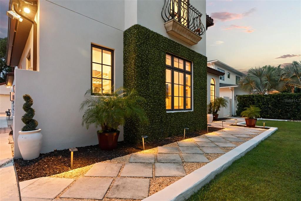 A modern house exterior features a green hedge wall, stone walkway, and a small balcony — 645 PANSY AVENUE, WINTER PARK, FL