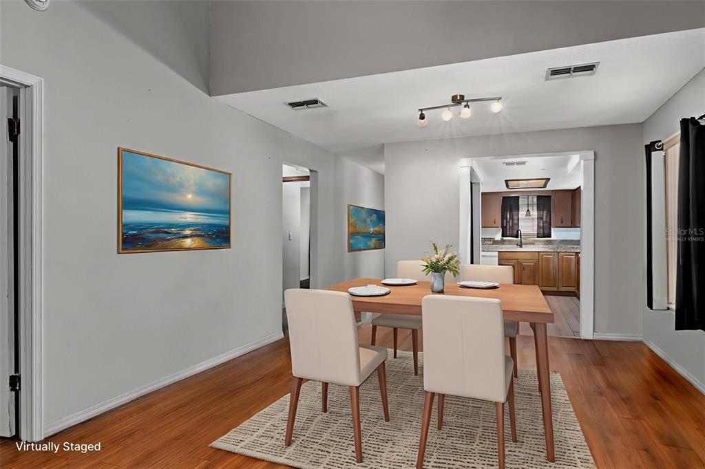 A dining room with a wooden table, four chairs, and a view into the kitchen — 35077 WHISPERING OAKS BOULEVARD, DADE CITY, FL