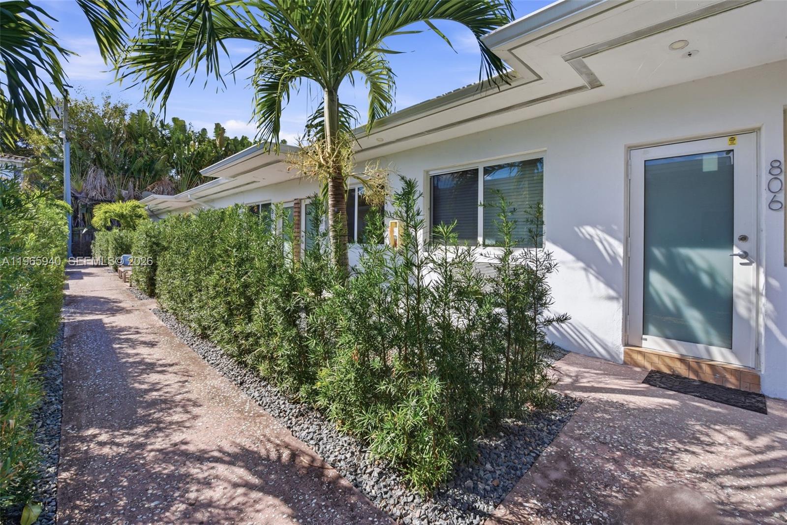 A white single-story building exterior features a walkway, a palm tree, and privacy hedges — 800 85th St, Miami Beach FL 33141, MIAMI BEACH, FL