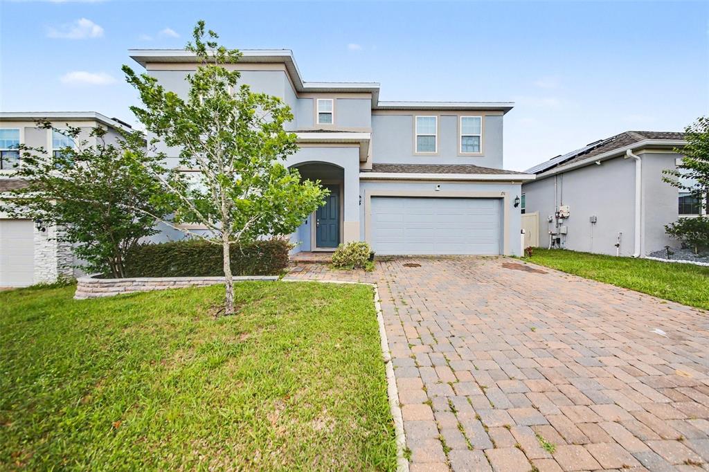 A two-story house with a blue exterior, a brick paver driveway, and a two-car garage — 191 HYDRA WAY, GROVELAND, FL