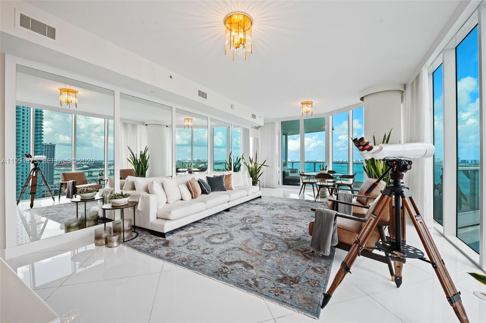 A bright living room features white tile floors, a large area rug, and floor-to-ceiling windows — 2020 N Bayshore Dr # 2502, Miami FL 33137, MIAMI, FL