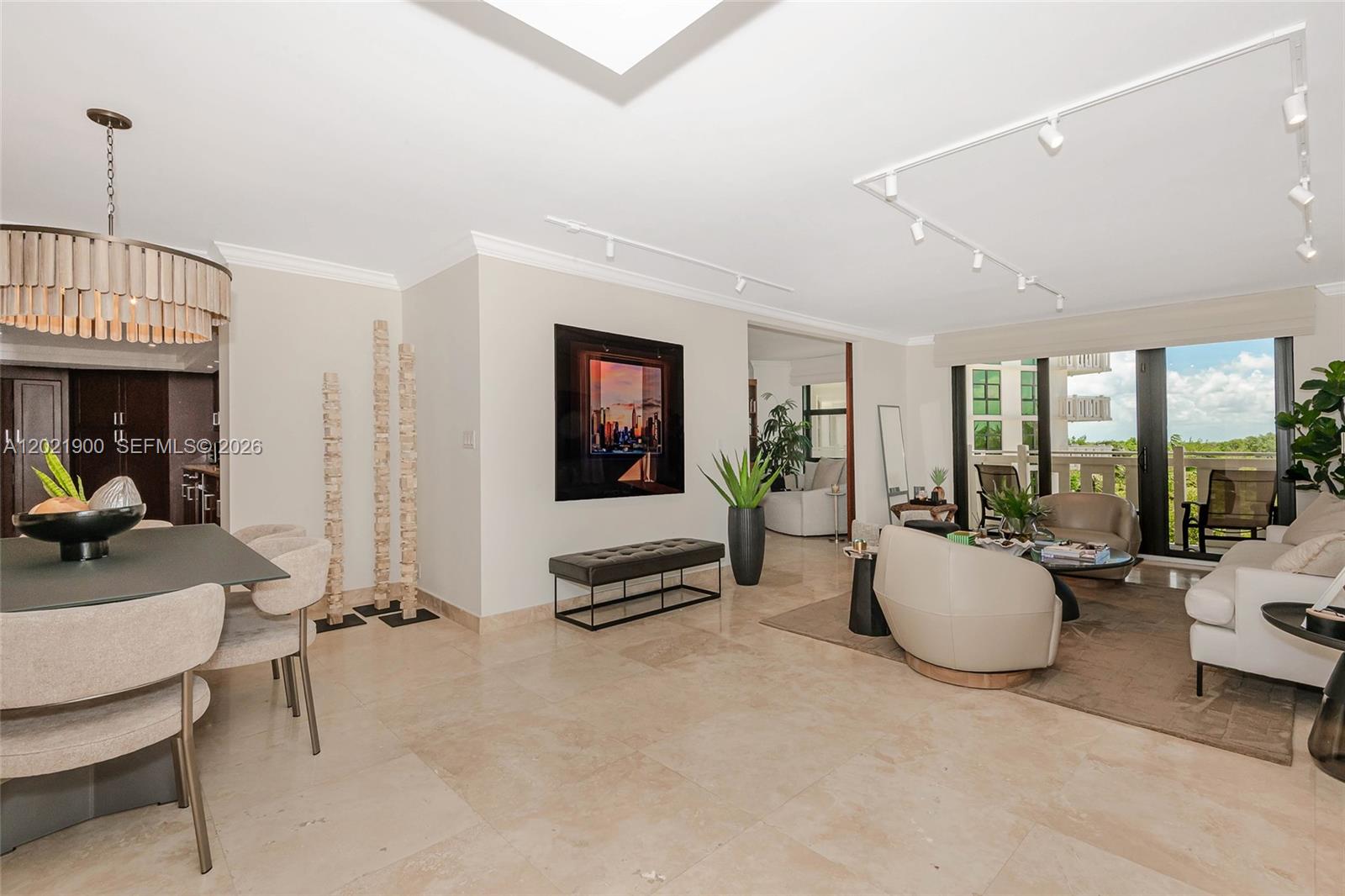 A bright, open-concept living and dining area features tile flooring, modern lighting, and balcony access — 1121 Crandon Blvd # E405, Key Biscayne FL 33149, KEY BISCAYNE, FL