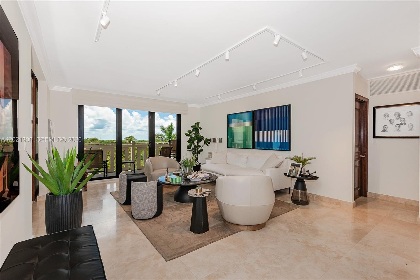 A bright living room features a white sofa, armchairs, marble floors, and a balcony view — 1121 Crandon Blvd # E405, Key Biscayne FL 33149, KEY BISCAYNE, FL