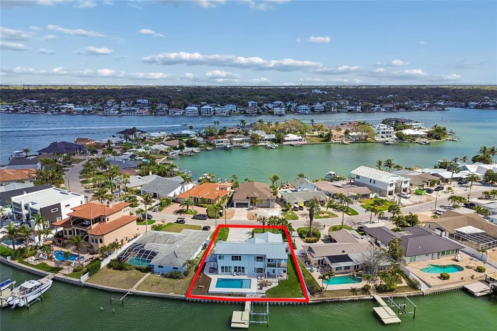 An aerial view shows a two-story waterfront house with a pool and private dock — 478 HARBOR DRIVE N, INDIAN ROCKS BEACH, FL