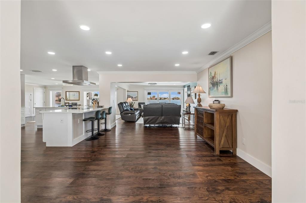 An open-concept living area features dark wood floors, a kitchen island, and a water view — 478 HARBOR DRIVE N, INDIAN ROCKS BEACH, FL