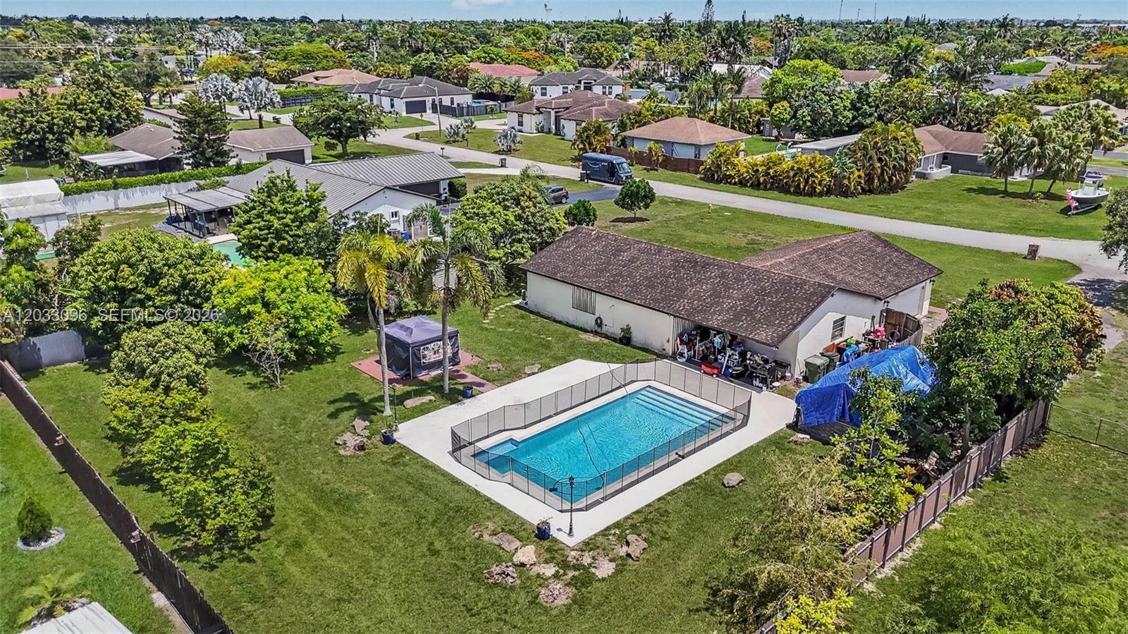 An aerial view shows a house with a fenced swimming pool in the backyard — 1475 NW 19 ST, Homestead FL 33030, HOMESTEAD, FL