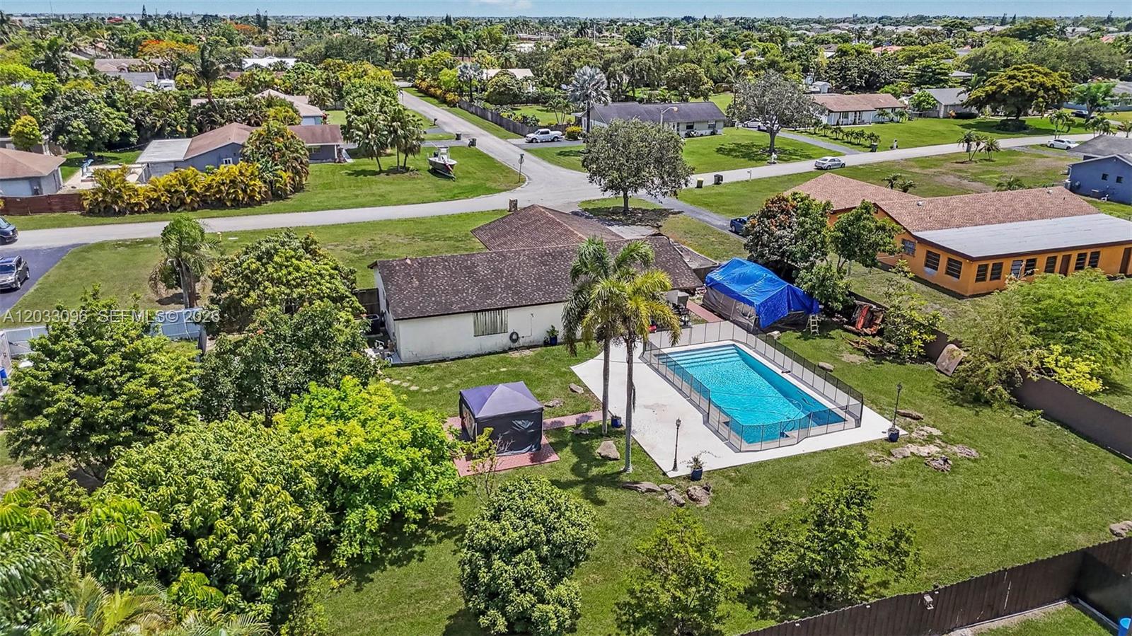 An aerial view shows a house with a backyard pool, patio, and surrounding trees — 1475 NW 19 ST, Homestead FL 33030, HOMESTEAD, FL