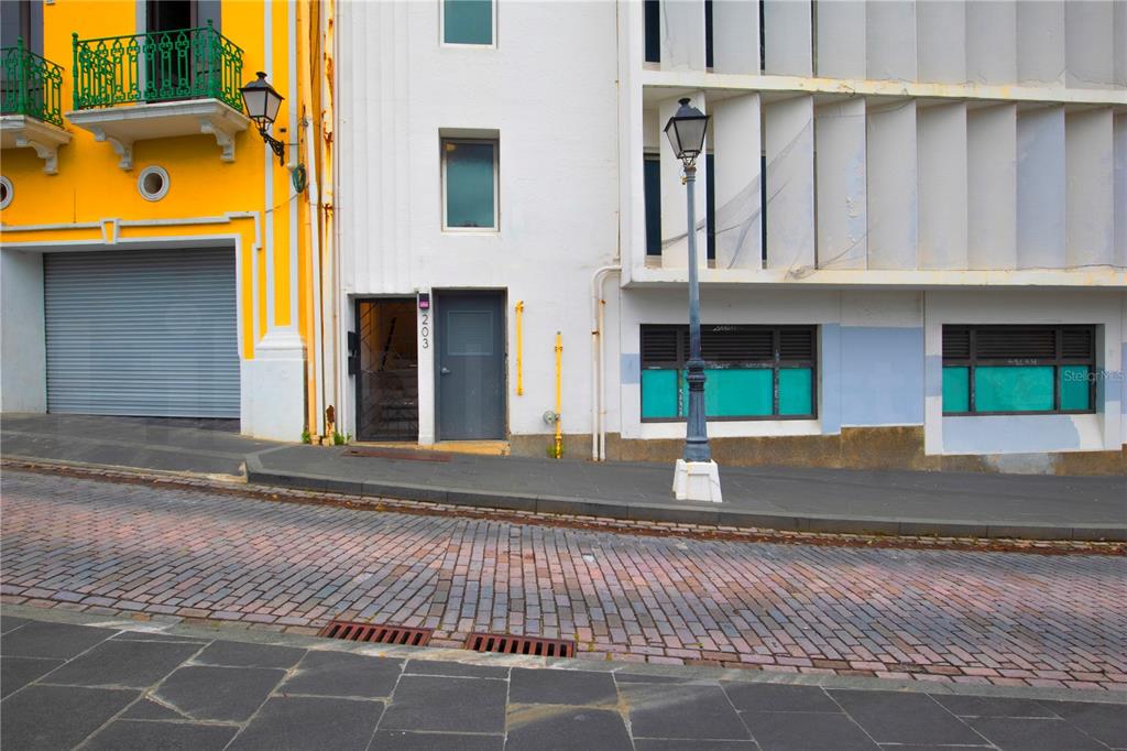 A street-level view of a yellow building and an adjacent white building with a door — 203 RECINTO SUR STREET UNIT 2, OLD SAN JUAN, PR