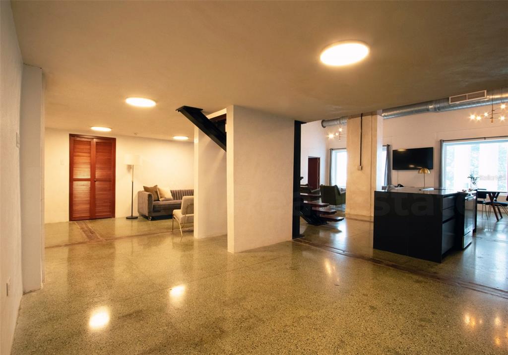 An open-concept interior features polished concrete floors, white walls, and a modern kitchen island — 203 RECINTO SUR STREET UNIT 2, OLD SAN JUAN, PR