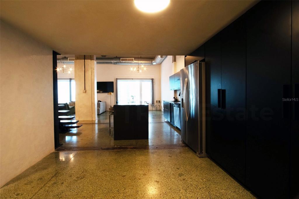 A modern kitchen with dark cabinetry and stainless steel appliances opens into a living area — 203 RECINTO SUR STREET UNIT 2, OLD SAN JUAN, PR