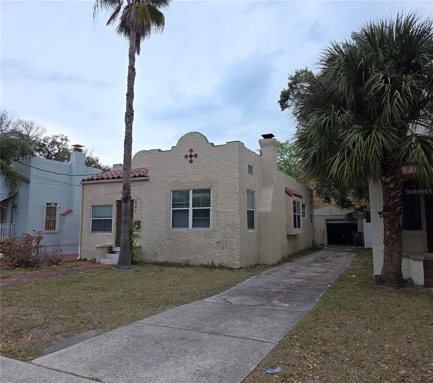 A single-story stucco house with a curved parapet roof and a concrete driveway — 847 S RIDGEWOOD AVENUE, DAYTONA BEACH, FL