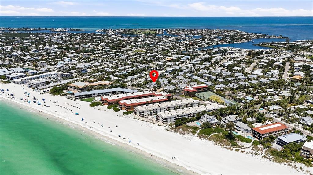 An aerial view shows a beachfront resort complex with a red location marker — 6325 GULF DRIVE, HOLMES BEACH, FL
