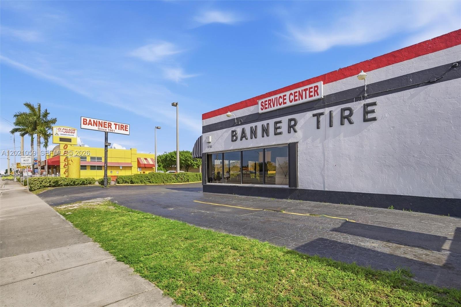 The exterior of a Banner Tire service center building features a white facade with black stripes — 8730 SW 8th St, Miami FL 33174, MIAMI, FL