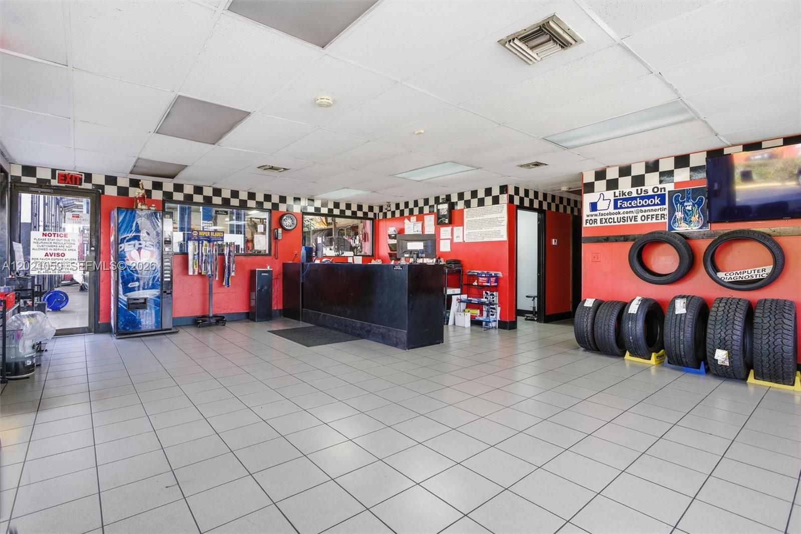 A commercial auto shop lobby features a service counter, tiled floors, and tires on display — 8730 SW 8th St, Miami FL 33174, MIAMI, FL