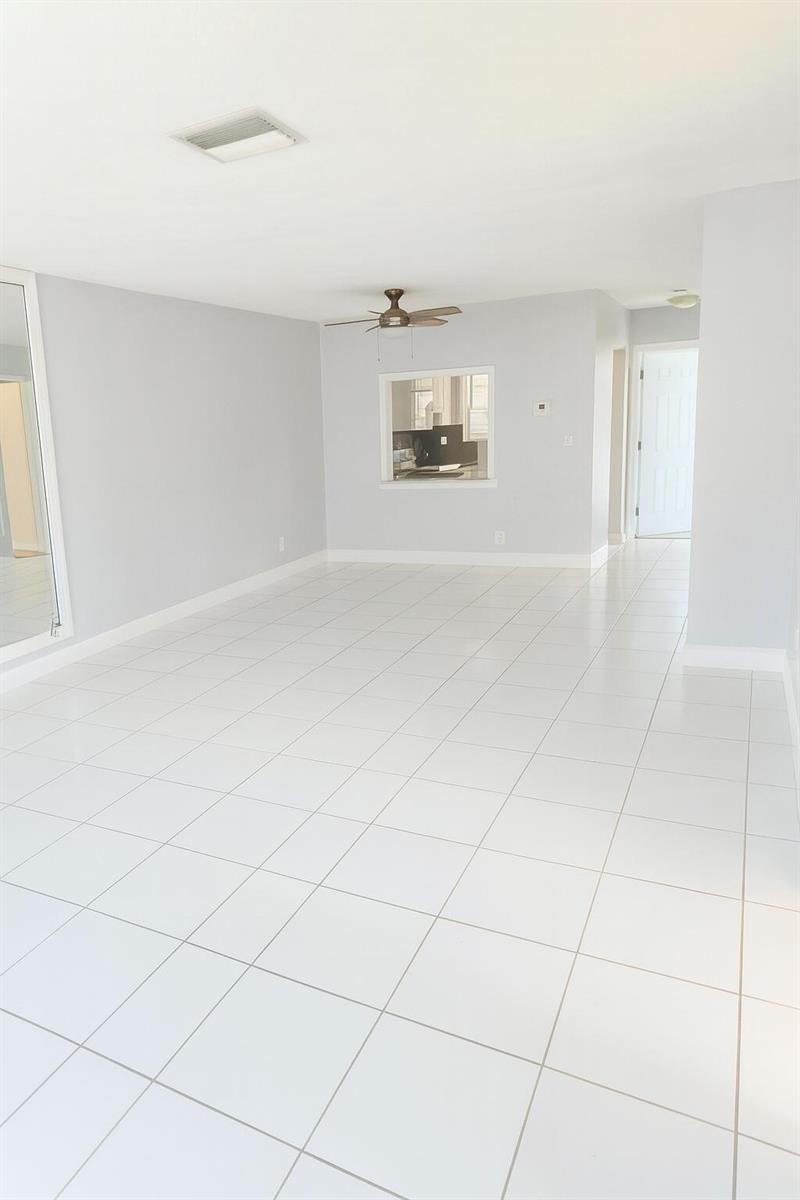 An empty room with white tile flooring, light gray walls, and a ceiling fan — 1001 SE 3rd Street # 3, Deerfield Beach FL 33441, DEERFIELD BEACH, FL