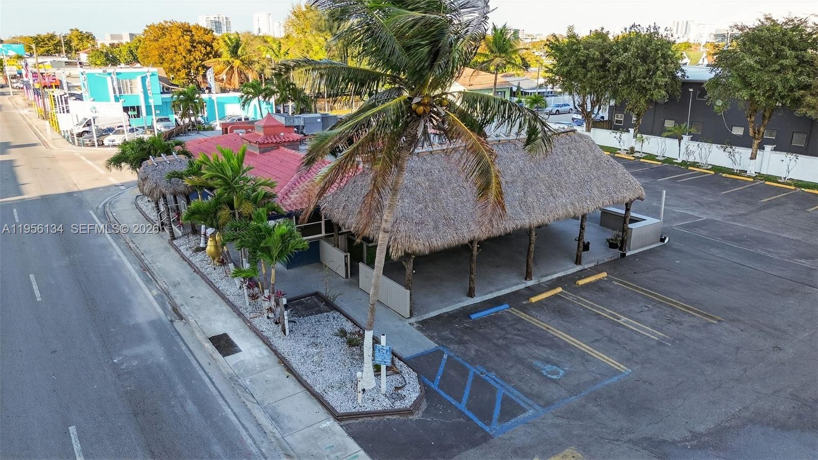 An aerial view shows a commercial building with a thatched roof and an adjacent parking lot — 45 NW 22 AVE, FL 33125, FL