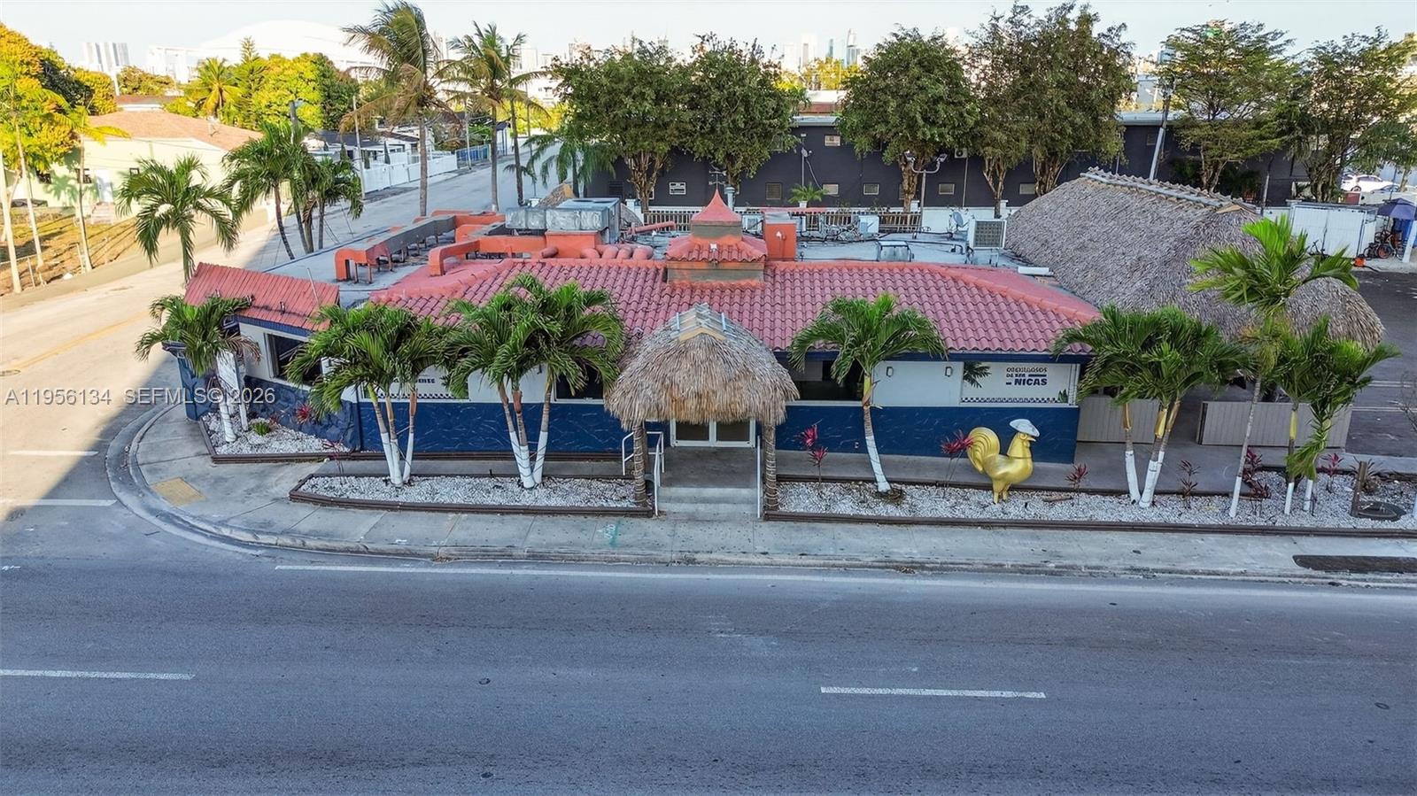 An exterior view of a single-story commercial building with a red tile roof and palm trees — 45 NW 22 AVE, FL 33125, FL