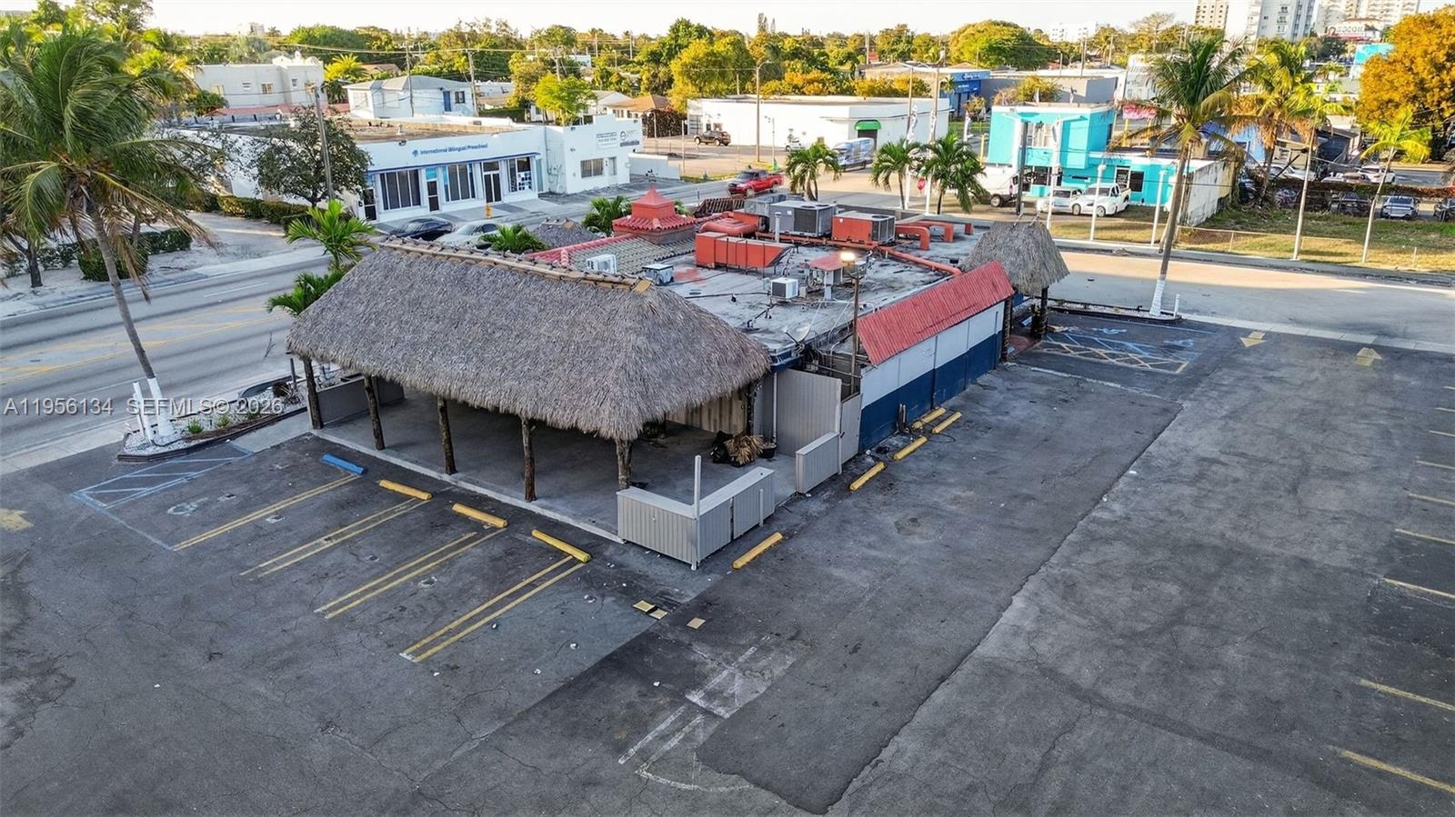 An aerial view shows a commercial building with a thatched roof and an adjacent parking lot — 45 NW 22 AVE, FL 33125, FL