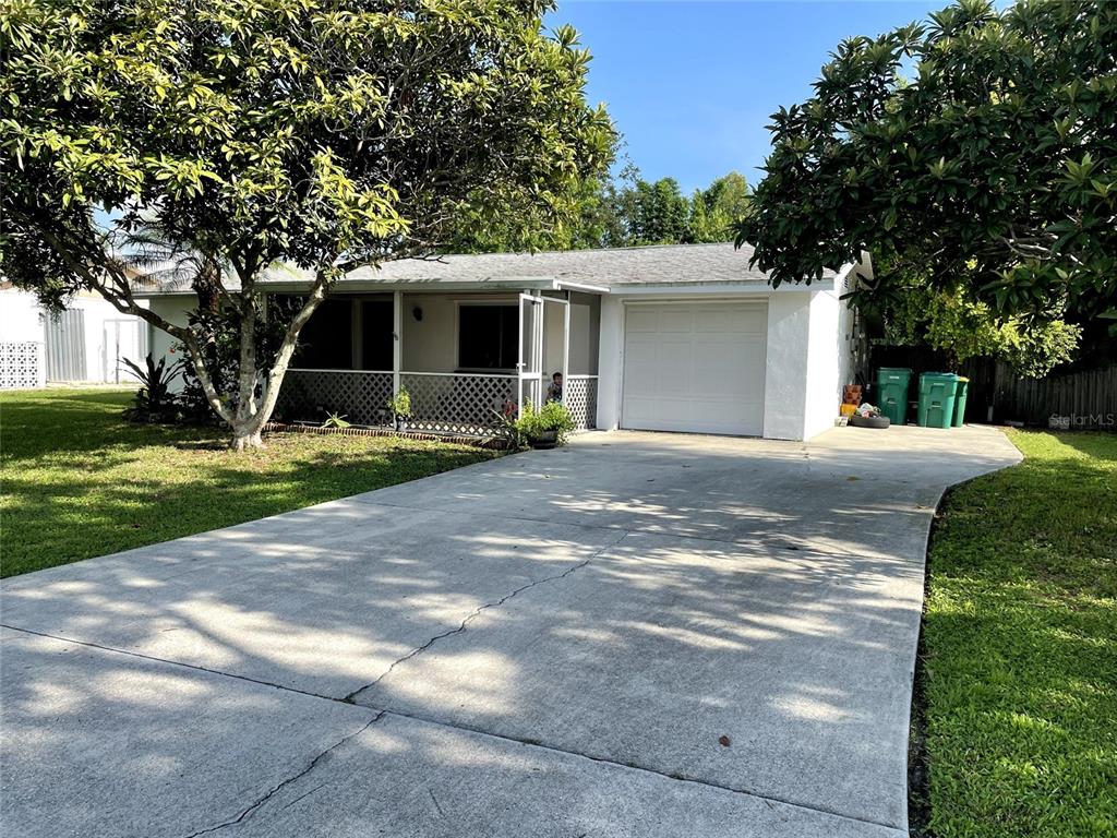 A single-story house with a white exterior, a front porch, and a concrete driveway — 210 WALNUT AVENUE NW, PORT CHARLOTTE, FL