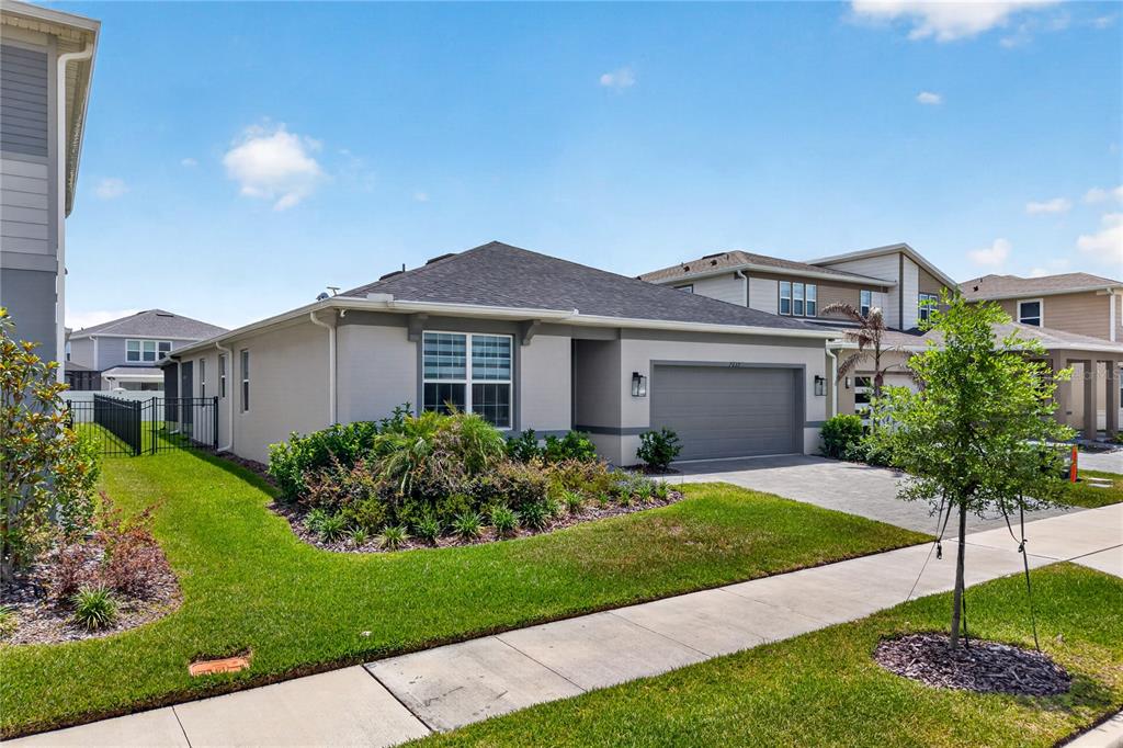 A single-story suburban house with a gray garage, stucco exterior, and a landscaped front yard — 7239 IVY TENDRIL AVENUE, ORLANDO, FL