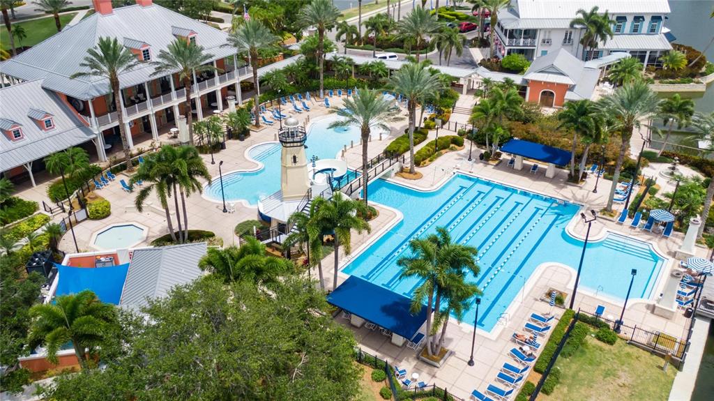An aerial view of a resort-style swimming pool complex with a lighthouse feature and palm trees — 1019 SIGNET DRIVE, APOLLO BEACH, FL