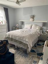 A bedroom features a bed with a white comforter, a wall shelf, and a ceiling fan — 4141 NW 44TH AVENUE UNIT 226, LAUDERDALE LAKES, FL