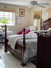 A bedroom features a wooden four-poster bed, tiled floors, a ceiling fan, and framed wall art — 4141 NW 44TH AVENUE UNIT 226, LAUDERDALE LAKES, FL