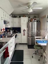 A kitchen features white cabinetry, stainless steel appliances, a ceiling fan, and a small dining table — 4141 NW 44TH AVENUE UNIT 226, LAUDERDALE LAKES, FL