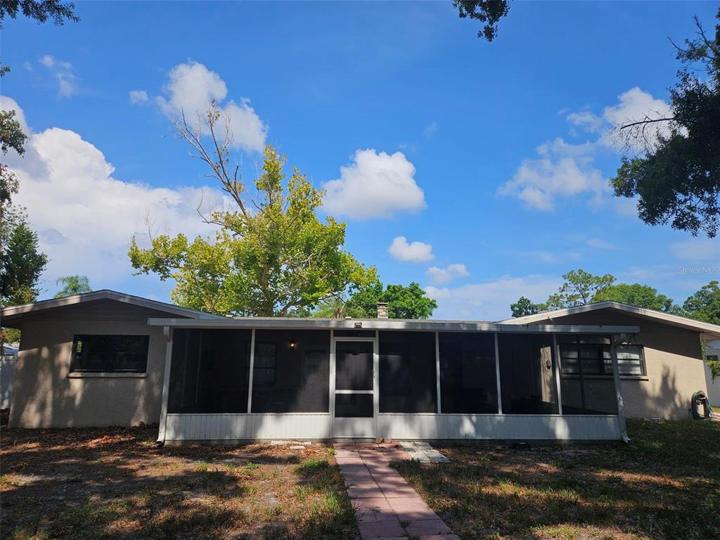 A single-story house features a large screened-in porch and a paved walkway in the yard — 1417 27TH STREET W, BRADENTON, FL