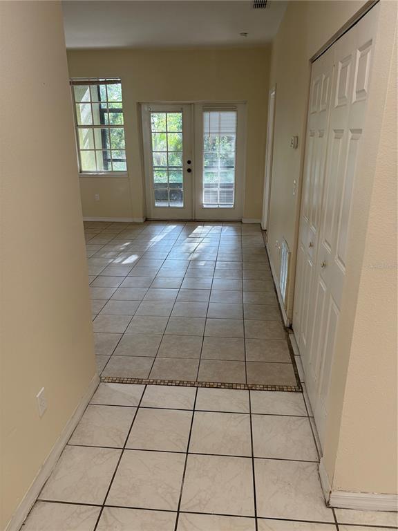 A tiled room features a glass door leading to a screened-in patio and a closet — 530 BELLTOWER AVENUE, DELTONA, FL
