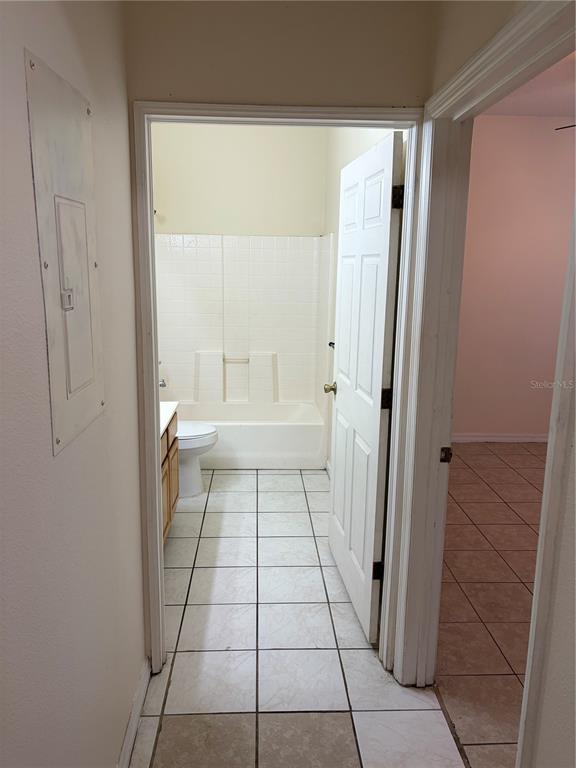 A hallway leads to a bathroom with a tub-shower combo and tiled floors — 530 BELLTOWER AVENUE, DELTONA, FL