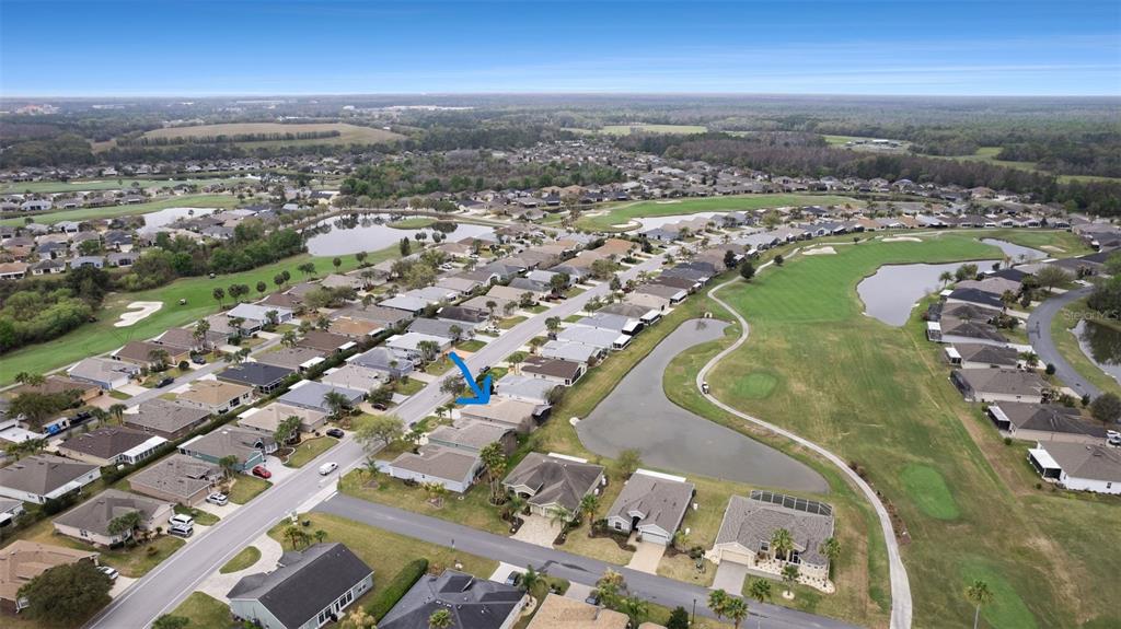 An aerial view shows a suburban neighborhood with houses, a golf course, and ponds — 10321 OLD TAMPA BAY DRIVE, SAN ANTONIO, FL