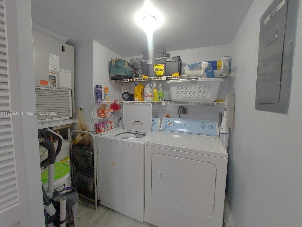 A laundry room features a white washer and dryer, wire shelving, and an HVAC unit — 16300 Golf Club Rd Apt 317, Weston FL 33326, WESTON, FL