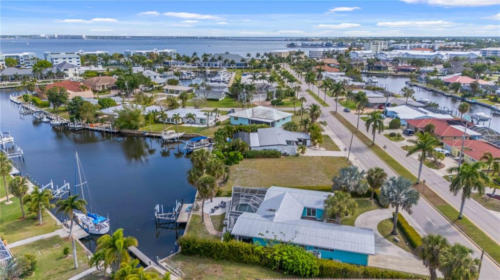 An aerial view of a waterfront house with a pool cage and private boat dock — 1960 W MARION AVENUE, PUNTA GORDA, FL