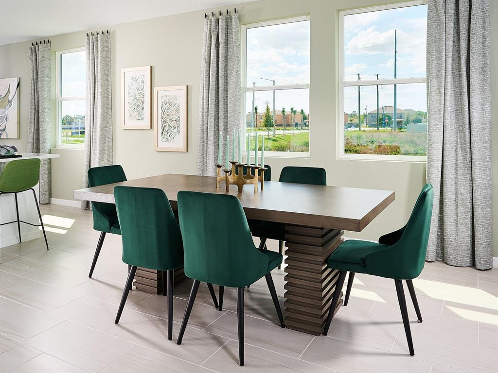 A dining room features a wooden table, green velvet chairs, and large windows with curtains — 5305 WILLOW CREEK, HAINES CITY, FL