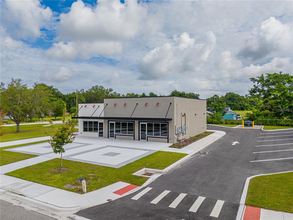 A modern, single-story commercial building with a paved parking lot and landscaped grounds — 215 CENTER STREET UNIT 227, WINTER GARDEN, FL